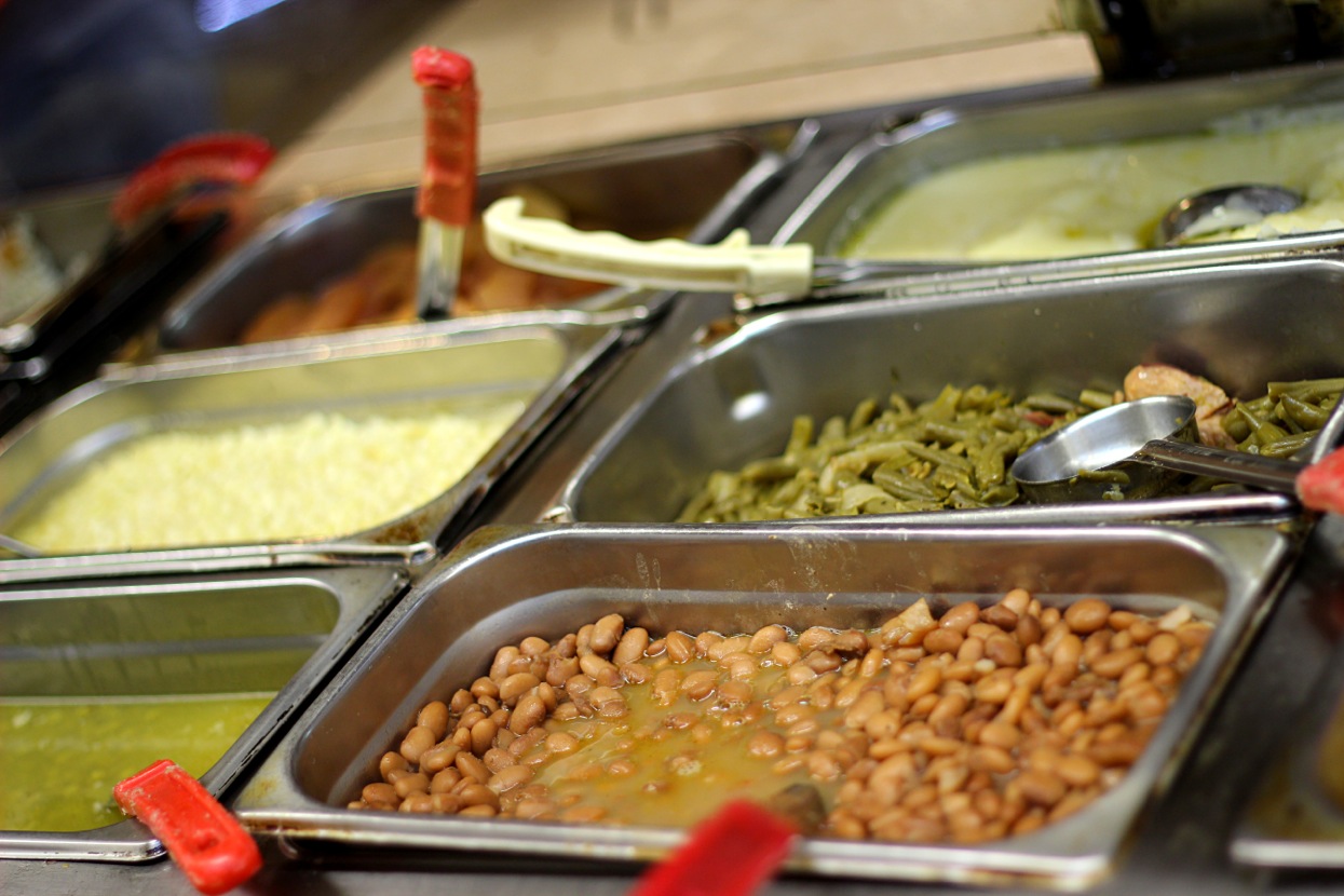 Steam table pans of pinto beans, green beans, creamed corn and greens on the Silver Sands serving line